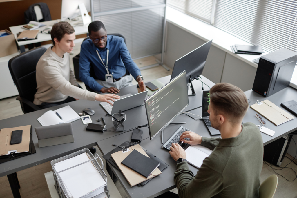 High-angle shot of busy professionals sitting at office desks while developing process automation protocols to streamline workflow in modern office